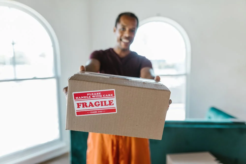 All your belongings will be handled with care when moving in Sheffield this summer Person holding fragile box