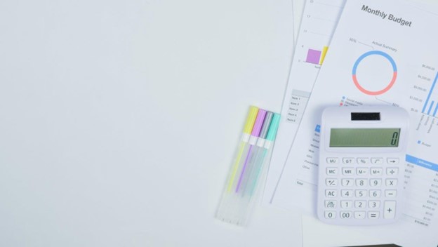 A calculator and papers on a white surface