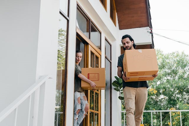 Early preparation and research always pays off Couple carrying boxes from a house